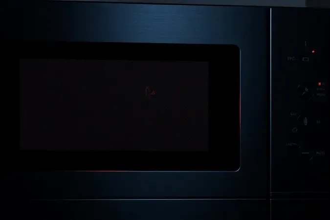Painel digital de micro-ondas exibindo indicador luminoso de erro em vermelho, close-up conceitual do display.