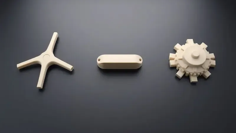 Renderização 3D comparando três tipos de encaixe para prato de micro-ondas: trevo em Y, liso e engrenagem, dispostos em linha sobre superfície escura.